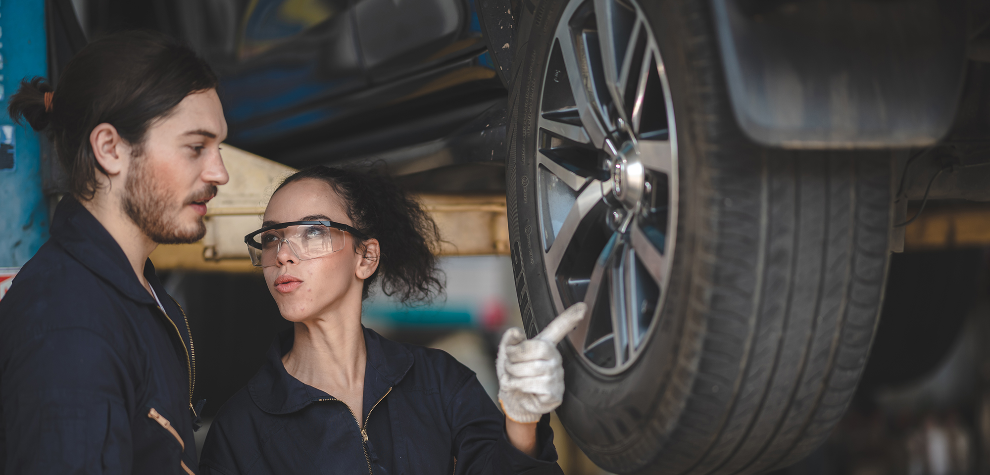 woman and man fixing on an automobile