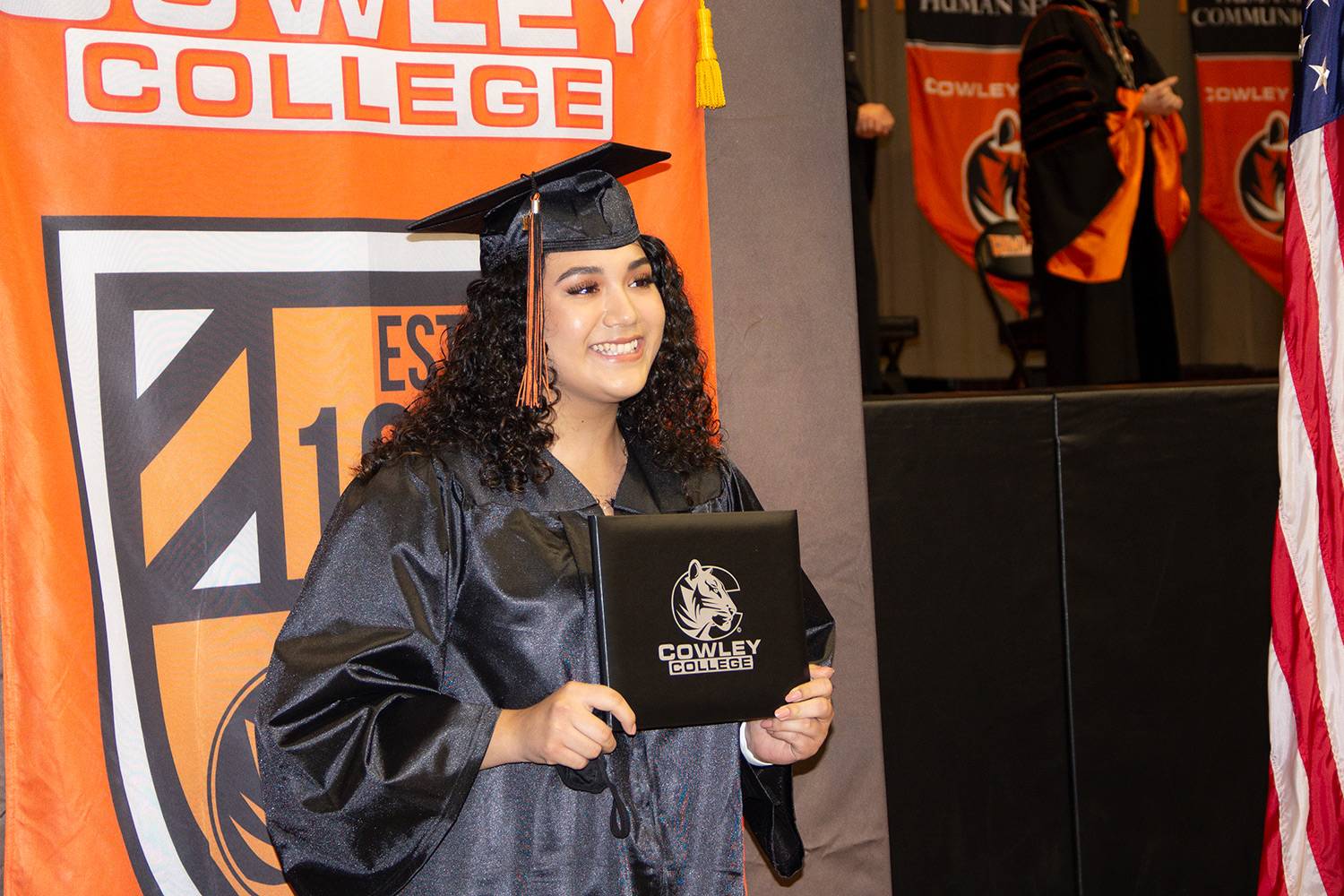 student holding diploma at commencement