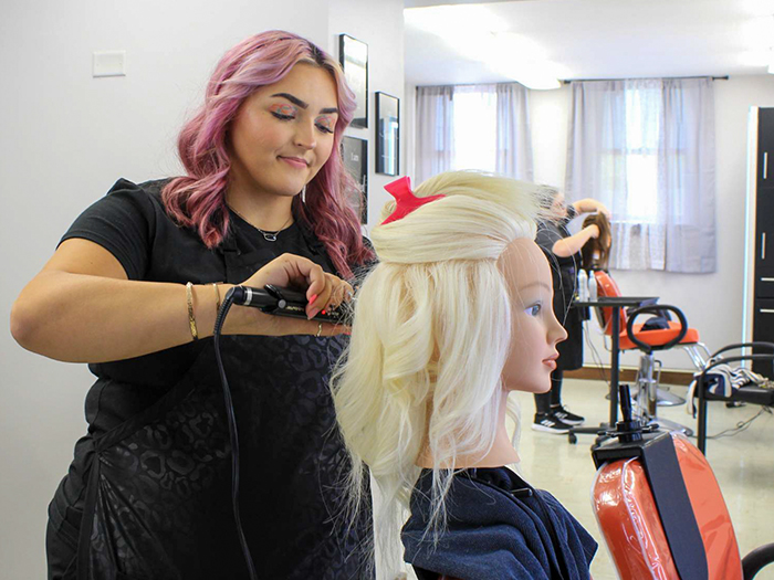 student cutting hair